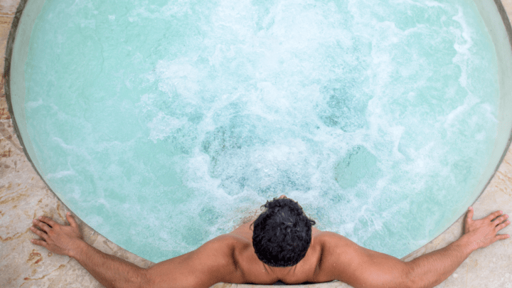 Man sitting in hot tub with water jets.